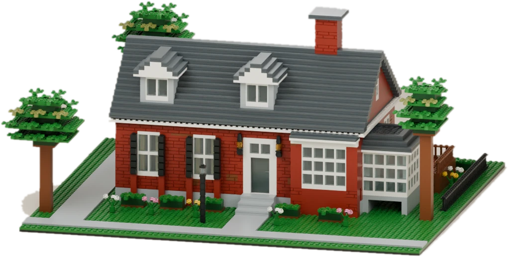 Brick model of a red brick house with dormer windows, a sunroom and leafy trees